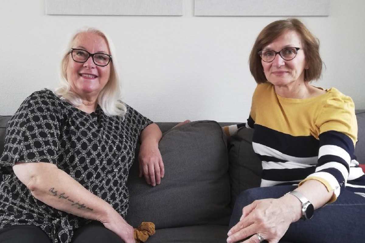 Två kvinnor sitter i en soffa