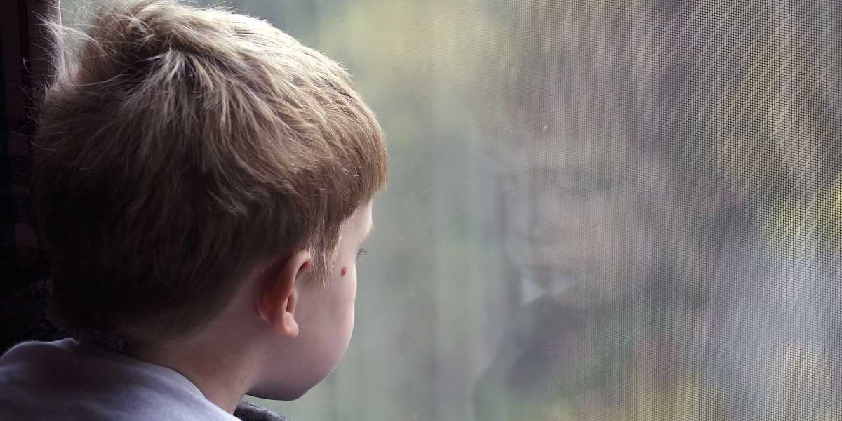 Pojke tittar ut genom fönstret