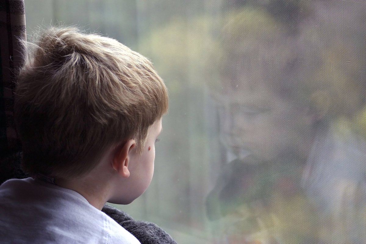 Pojke tittar ut genom fönstret